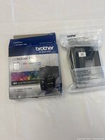 Top view of the Brother LC3033BK XXL cartridge with original box showing front and cartridge in sealed plastic bag.