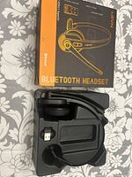 Front view of LEVN Bluetooth headset in original box with molded plastic insert and USB wireless receiver visible