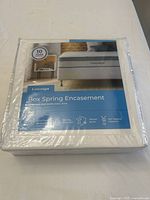 Box spring encasement in sealed packaging showing front label and product information.