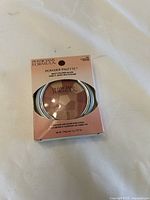 Front view of boxed Physicians Formula Powder Palette multi-colored blush in Blushing Rose shade showing the product through transparent window in rose-gold cardboard packaging.