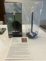 Box and lamp in plastic wrap with USB charging cable and instruction sheet on table.