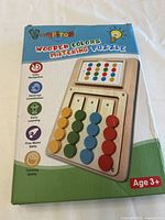 Front of the wooden colors matching puzzle box showing the puzzle design and features including color recognition and fine motor skills, with recommended age 3+.