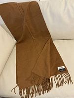 Full view of draped nutmeg cashmere scarf showing fringe and overall texture.
