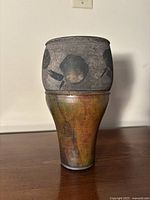 Front view of the vintage art pottery vase showing upper matte grey with floral motif and lower amber brown glaze.
