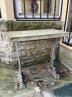 Full view of table showing cast iron frame and stone top