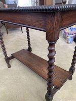Close-up of table side showing circular beaded trim and barley twist legs