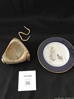 Photo showing both the steatite stone carving bowl and Emily Carr decorative plate side by side on a black cloth.