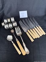 Seven silver plated napkin rings, some with embossed patterns, one visible hallmark noted, arranged in a group.