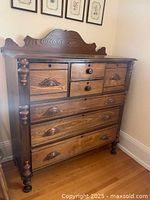 Full front view of chest showing carved bonnet top, seven drawers and turned posts