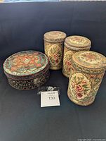 All four vintage tin canisters shown in a group with visible signs of rust and wear.