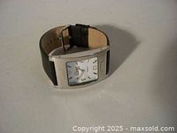 Fossil rectangular wristwatch with Roman numeral hour markers and black leather strap shown.