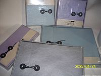 Group photo showing eight handmade reusable envelopes in pastel colors with string-button closures arranged for display.