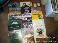 Photo showing a collection of around 17 classic rock vinyl LP albums arranged in a partial grid on the floor featuring colorful album covers including titles 'Volunteers', 'Matchbox', 'Easy Rider', among others.