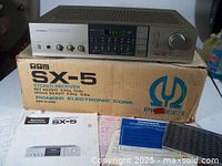 Pioneer SX-5 stereo receiver on top of original box accompanied by manuals and additional papers.