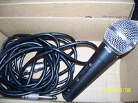 Photo of the black Pyle microphone with cord coiled beside it showing the 1/4-inch jack.