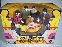 Front view of the vintage Beatles Yellow Submarine figures set in original box showing four Beatles figures and the submarine model.