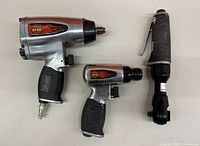 Three Hotrod compression tools arranged on a table including two pneumatic impact wrenches and one ratchet wrench