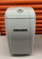 Front view of white Mobicool mobile fridge with digital control panel on top and brand name on front.