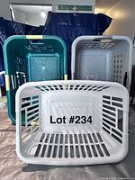 Three plastic laundry baskets stacked; one teal and two gray colors shown from top-down angle to highlight ventilation holes and handles.