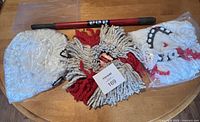 Set of extendable handle and three mop heads: one used and two new in bags, laid on table.