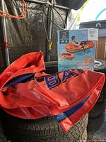 Red vinyl inflatable tube with blue and black detailing placed on tires.