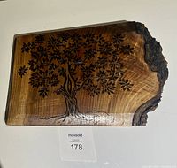 Front view of rectangular wooden plaque showing live edge on right side with detailed burnt tree design covering most of surface.
