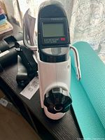 Mini exercise bike digital monitor and adjustable knob visible on device.