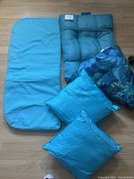 Overview of all six cushions showing different sizes, shapes, and patterns in turquoise and blue.