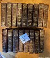 Photo of 17 Readers Digest hardcover books standing side by side showing spines with titles and gold embossed reading 'Reader's Digest Condensed Books'