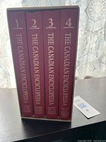 Four hardcover volumes of The Canadian Encyclopedia in a slipcase consistent with 1985 production, showing spine titles and numbering.
