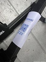 Close-up of black Thule cross bar with label showing MaxSold tag on surface