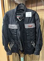Front view of black Kilmarnock motorcycle jacket showing flap chest pockets with Kilmarnock and Pyrotech branding.