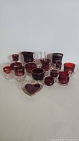 Group of 16 ruby flash antique early American press glass pieces including creamers, bowls, and cups with clear glass accents and ruby overlay