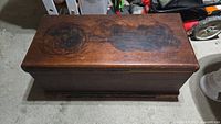 Top view of antique wooden blanket box showing dark stains and scratches on the lid surface
