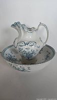 Front view of the antique pitcher and wash basin set showing detailed floral patterns