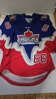Front view of blue and red Reebok Toronto Rock lacrosse jersey with number 66 on both sleeves and bottom front right.