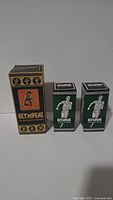 Three vintage unopened Olympene The Antiseptic Liniment boxes shown front-facing on a neutral background.