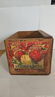 Front view of wooden crate showing original colorful Yakima Apples label with red and yellow apples and Red Ribbon branding.
