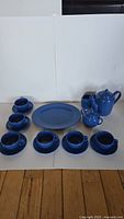 16-piece blue ceramic tea set featuring teapot, sugar bowl, creamer, six cups with six saucers, and serving platter.