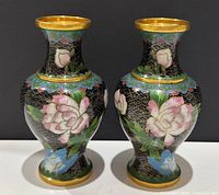 Pair of small Chinese cloisonne vases with floral designs on black background, brass rims top and bottom