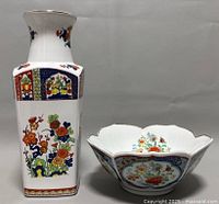Photo showing the vintage Imari lotus flower bowl and floral square vase side by side on gray background, highlighting the colorful hand-painted floral and geometric patterns.