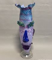 Front view of the handmade art glass face vase showing detailed facial features including blue nose, green eyebrows, and ruffled top.