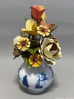 Front angle showing handcrafted metal flowers in vase with Royal Dutch hand painted motifs.