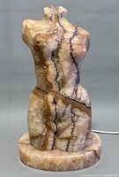 Front view of the natural stone carved female torso sculpture lamp showing colors and texture.