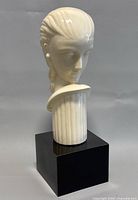 Front angled view of the porcelain lady bust showing detailed facial features and hairstyle on black wooden base.