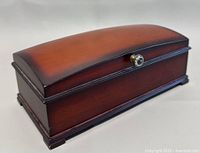 Closed view of the wood jewelry box showing curved lid and knob.