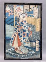 Full view of framed vintage Asian woodblock print showing a woman in kimono, with traditional outdoor setting and Japanese text.