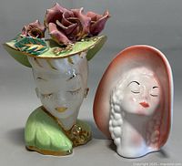 Two vintage lady head vases shown side-by-side, front view highlighting facial features and coloration.