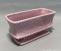 Front angle view showing the raised wavy textured design and dotted rim on the light purple McCoy ceramic footed planter.