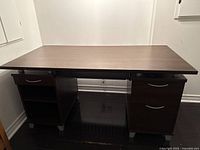 Front view of the desk showing the pull-out keyboard tray, two drawers with metal handles on the right, and two open shelves on the left.